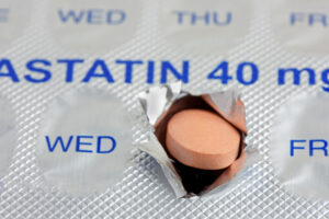 A statin tablet emerging from a marked weekly blister pack